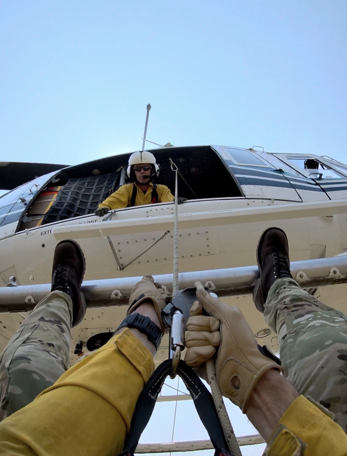 A rappeller’s-eye view of a North Idaho Rappellers helicopter insertion, with the spotter monitoring the descent from the aircraft.