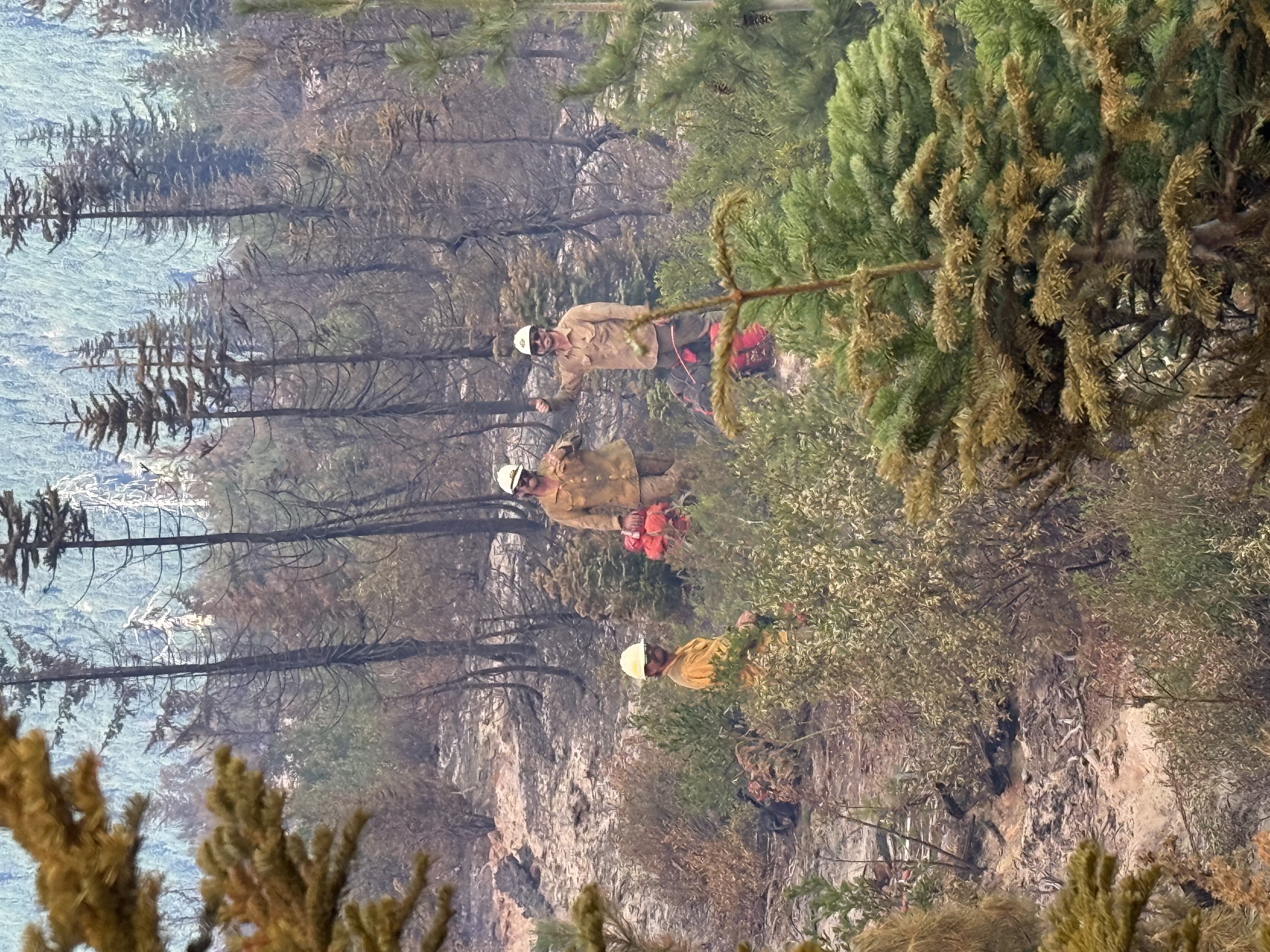 Heli-rappellers prepare for a packout after a remote wildfire assignment, organizing gear for the hike back to accessible terrain.